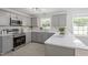 Stylish kitchen boasting gray cabinets, stainless steel appliances, and white countertops with backsplash at 7824 Knightdale Blvd, Knightdale, NC 27545