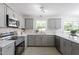 Modern kitchen with gray cabinetry, stainless steel appliances, and white countertops at 7824 Knightdale Blvd, Knightdale, NC 27545