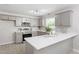 Modern kitchen featuring gray cabinets, quartz countertops, and stainless steel appliances at 7824 Knightdale Blvd, Knightdale, NC 27545