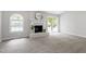 Bright living room featuring a cozy fireplace, arched window, and sliding glass door at 7824 Knightdale Blvd, Knightdale, NC 27545