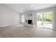 Bright living room featuring a cozy fireplace, arched window, and sliding glass door at 7824 Knightdale Blvd, Knightdale, NC 27545