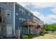 Exterior back view of townhomes featuring private wooden decks, back doors, and lawn at 805 Grafton Peak Lane Ln, Apex, NC 27523