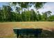 Take a seat on the bench within the community green space, surrounded by a lush tree line at 805 Grafton Peak Lane Ln, Apex, NC 27523