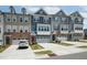 Modern townhomes feature multi-toned exteriors and attached garages with driveways at 805 Grafton Peak Lane Ln, Apex, NC 27523
