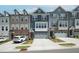 Modern townhomes feature multi-toned exteriors and attached garages with driveways at 805 Grafton Peak Lane Ln, Apex, NC 27523
