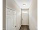 Well-lit hallway featuring a sleek wood floor and classic white doors at 805 Grafton Peak Lane Ln, Apex, NC 27523