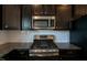 Close up of gourmet kitchen with stainless appliances, granite countertops, and subway tile at 805 Grafton Peak Lane Ln, Apex, NC 27523
