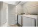 Functional laundry room with modern washer and dryer, storage shelves, and tile flooring at 805 Grafton Peak Lane Ln, Apex, NC 27523