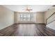 Bright, open living room featuring hardwood floors, large window, and ceiling fan at 805 Grafton Peak Lane Ln, Apex, NC 27523