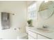 Bright bathroom with a plant, white sink, toilet, a round mirror, and a towel rack with a towel at 816 Roanoke Dr, Cary, NC 27513