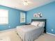Cozy bedroom featuring neutral carpet, blue walls, windows offering natural light, and a ceiling fan at 816 Roanoke Dr, Cary, NC 27513