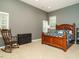 Bedroom with a wooden bed frame, grey walls, and natural light from two windows at 816 Roanoke Dr, Cary, NC 27513