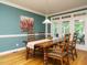 Well-lit dining room with wood floors, classic table and chairs, and doors to outdoor space at 816 Roanoke Dr, Cary, NC 27513