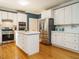 White kitchen with stainless steel appliances, central island, and hardwood floors at 816 Roanoke Dr, Cary, NC 27513