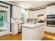 Bright kitchen with white cabinetry, stainless steel appliances, island, and access to the screen porch at 816 Roanoke Dr, Cary, NC 27513