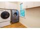 Laundry room featuring washer and dryer units, white cabinetry and window at 816 Roanoke Dr, Cary, NC 27513