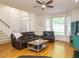 Bright living room with hardwood floors, bay windows, and comfortable leather furniture at 816 Roanoke Dr, Cary, NC 27513