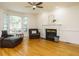 Inviting living room with a cozy fireplace, ceiling fan, and large windows for natural light at 816 Roanoke Dr, Cary, NC 27513