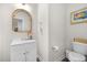 Bathroom with a bright vanity, toilet, and an arched mirror and decorative accents at 820 Laurel Gate Dr, Wake Forest, NC 27587