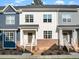 Neat townhome exterior offers a welcoming entryway, brick accents, and steps that lead up to a cozy front porch at 820 Laurel Gate Dr, Wake Forest, NC 27587