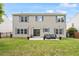 Two story home has large backyard with lawn, patio with furniture, and black fence at 8408 Haines Creek Ln, Raleigh, NC 27616