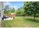 Backyard featuring grass, a wooden fence, and a concrete patio with furniture and mature trees at 8408 Haines Creek Ln, Raleigh, NC 27616