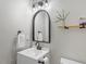 Well-lit half-bathroom features a sleek mirror, floating shelf, and modern fixtures at 8408 Haines Creek Ln, Raleigh, NC 27616