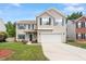 Two-story home with green shutters, a two-car garage, and a well-manicured lawn on a clear day at 8408 Haines Creek Ln, Raleigh, NC 27616