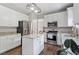 Bright kitchen features white cabinets, stainless steel appliances, granite counters, and wood flooring at 8408 Haines Creek Ln, Raleigh, NC 27616