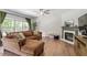 Relaxing living room boasts a fireplace, ceiling fan, plush sofa, and bright windows at 8408 Haines Creek Ln, Raleigh, NC 27616