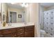 Bathroom with double vanity, and a shower behind a patterned shower curtain at 846 Lake Artesia Ln, Fuquay Varina, NC 27526
