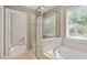 Bathroom features glass enclosed shower and a tub, brightened by a window at 846 Lake Artesia Ln, Fuquay Varina, NC 27526