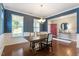 Well-lit dining room featuring hardwood floors, modern chandelier, and view of the front yard through bright windows at 846 Lake Artesia Ln, Fuquay Varina, NC 27526