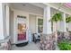 Welcoming front porch is adorned with stone columns and hanging ferns at 846 Lake Artesia Ln, Fuquay Varina, NC 27526