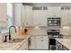 Modern kitchen featuring stainless steel appliances, granite countertops, white cabinets, and sleek faucet at 846 Lake Artesia Ln, Fuquay Varina, NC 27526