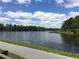 Scenic waterfront view with a paved path along the lake surrounded by lush greenery at 846 Lake Artesia Ln, Fuquay Varina, NC 27526