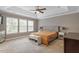 Bright main bedroom with tray ceiling, neutral decor, and three sunny windows at 846 Lake Artesia Ln, Fuquay Varina, NC 27526