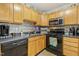 Updated kitchen features sleek black appliances, stylish tile backsplash and wood cabinetry at 8640 Neuse Landing Ln # 110, Raleigh, NC 27616