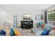 Bright living room with cozy gray sectional, throw pillows, a modern entertainment center, and ample natural light at 8640 Neuse Landing Ln # 110, Raleigh, NC 27616