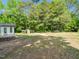 Wide backyard with a chicken coop and wooden structures in a lush, grassy area at 8731 Raleigh, Benson, NC 27504