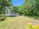 Expansive backyard view with a chicken coop, wooden structures, and a well-maintained lawn at 8731 Raleigh, Benson, NC 27504