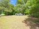 A house with a spacious front yard, shaded by mature trees and featuring a well-kept lawn at 8731 Raleigh, Benson, NC 27504