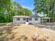 Charming white brick home featuring a metal roof, brown shutters, and a convenient carport at 8731 Raleigh, Benson, NC 27504
