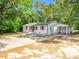 Angle view of the home, showcasing white brick, a metal roof, and a convenient carport at 8731 Raleigh, Benson, NC 27504