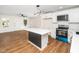 Bright kitchen with new appliances, white cabinets, an island with countertop, and wood flooring at 8731 Raleigh, Benson, NC 27504