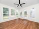 Bright living room with multiple windows and door providing natural light and wood floors with a ceiling fan at 8731 Raleigh, Benson, NC 27504