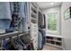 Walk-in closet with custom shelving, ample storage, and a window at 9625 Collins Creek Dr, Chapel Hill, NC 27516
