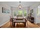 Dining area featuring hardwood floors, a bench, and bright windows with views of trees at 9625 Collins Creek Dr, Chapel Hill, NC 27516