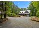 Charming two-story home with a metal roof, covered porch, and gravel driveway at 9625 Collins Creek Dr, Chapel Hill, NC 27516