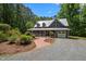 Stunning exterior showcasing a home with a metal roof, long front porch, and beautiful brick walkway and landscaping at 9625 Collins Creek Dr, Chapel Hill, NC 27516